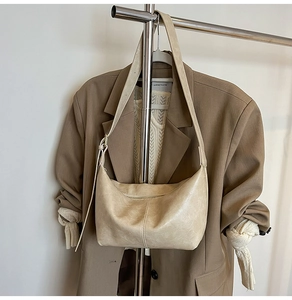 Detail of cream hobo bag with wrinkled leather texture and adjustable shoulder strap