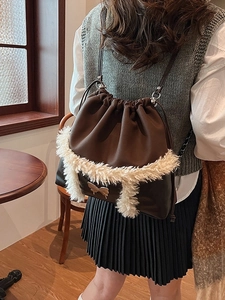 Chic dark brown drawstring bucket bag with white faux fur trim and gold bow buckle