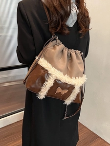 Fashionable patchwork drawstring shoulder bag with silver butterfly and plush trim