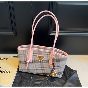 Détail du sac cabas à carreaux avec bordure en cuir rose et pendentif clochette