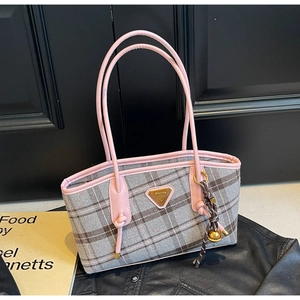 Détail du sac cabas à carreaux gris avec anses en cuir rose et plaque dorée