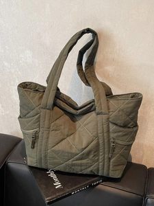 Olive green quilted tote bag with diamond stitching and side zipper pockets for women