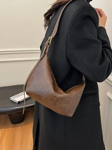 Vintage brown leather hobo bag for women with adjustable strap in a minimalist style