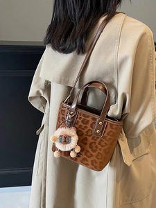 Classic brown leopard print mini bucket bag with lion charm and adjustable shoulder strap