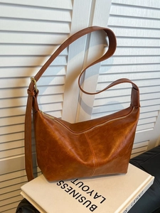 Vintage caramel oil wax leather shoulder bag with adjustable strap on white background