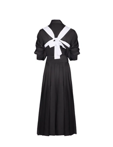Detail of the back of a black satin cosplay dress featuring a large white bow tie design