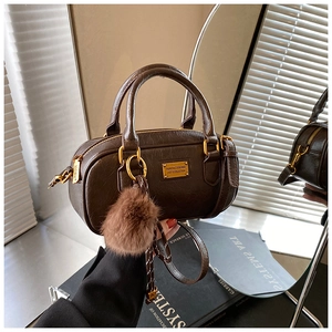 Detailed shot of dark brown Boston bag with pleated faux leather texture and gold hardware