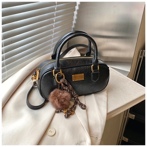 Detail of black wrinkled leather texture and golden hardware on the Boston bag