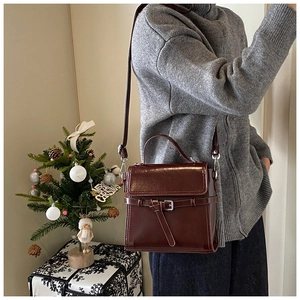 Detailansicht einer dunkelroten Vintage-Handtasche mit Schnallendesign in Feststimmung