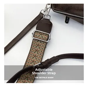 Detail of dark brown retro textured bag with bohemian jacquard strap and silver hardware