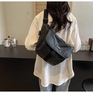 Detail achteraanzicht van een grote zwarte nylon crossbody tas met brede schouderband