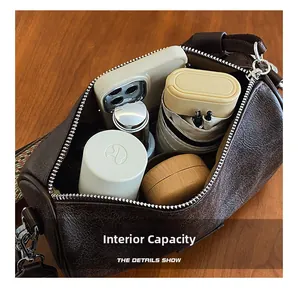 Interior view showing the large capacity of the brown cylinder bag with wide strap