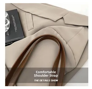 Detail shot of comfortable brown faux leather shoulder straps on a khaki tote bag