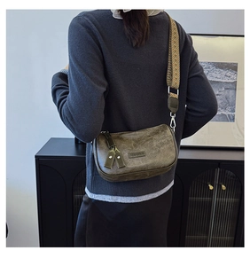 Detail of dark green retro pillow bag with a wide ethnic style woven shoulder strap