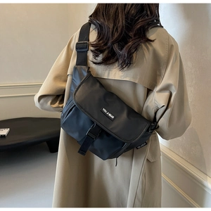 Zwarte nylon crossbody tas met verstelbare brede schouderriem en label op het model