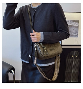 Detail of dark olive Boston bag featuring vintage texture and wide woven shoulder strap