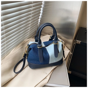 Dettaglio della borsa Boston patchwork in denim con cerniere dorate e tracolla rimovibile