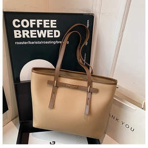 Close-up of lychee grain faux leather tote bag with elegant gold metal buckle detail