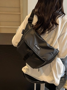 Grote zwarte casual crossbodytas met brede schouderriem en gespsluiting op de klep