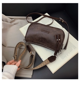 Detail of dark brown retro pillow bag with silver hardware and dual interchangeable straps