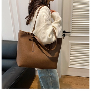 Side view of caramel brown pebble leather tote bag worn by a model for a commute look
