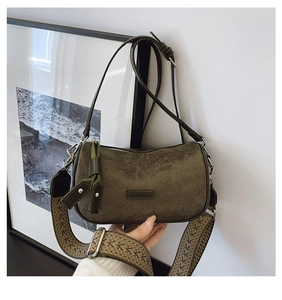 Detail of vintage olive green leather bag with wide ethnic pattern strap and metal brand tag