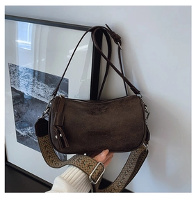 Detail of retro dark brown crossbody bag with colorful ethnic style woven shoulder strap