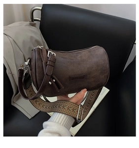 Detail of retro dark brown cylinder crossbody bag with colorful woven guitar shoulder strap