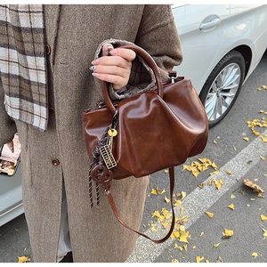 Gros plan d'un sac seau plissé vintage avec breloques rétro et texture brillante