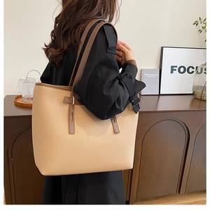 Detail of minimalist large tote bag featuring lychee texture and contrast straps