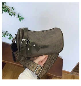 Detail of vintage textured olive green crossbody bag with ethnic patterned wide strap