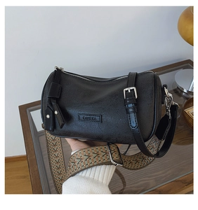 Detail of black cylindrical crossbody bag with vintage wide strap and silver metal hardware
