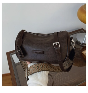 Detail of dark brown vintage pillow bag featuring textured leather and wide jacquard strap