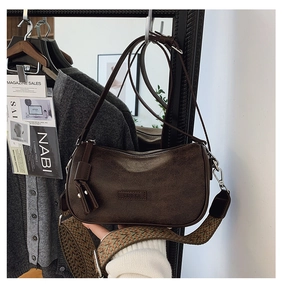 Retro dark brown crossbody bag detail showing vintage wide strap and brand logo