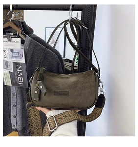 Detail of dark olive green crossbody bag with bohemian patterned wide strap and silver hardware