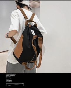 Detail of multi-way canvas backpack featuring brown contrast straps and side pocket