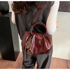 Détail du sac nuage plissé bordeaux avec poignée ronde et nœud tressé élégant