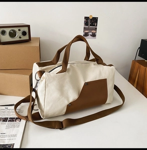 Close-up of vintage beige canvas travel bag with leather straps and metallic rivets