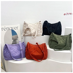 Detailed look at five colors of quilted nylon tote bags on white geometric displays