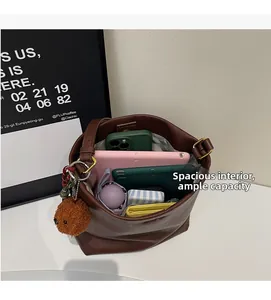 Top view of large brown bucket bag showing internal space with phone, tablet, and umbrella