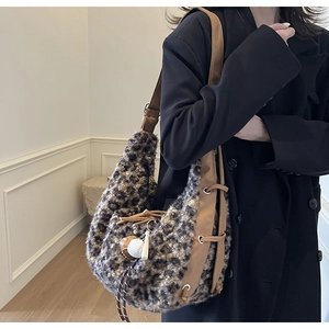 Detail view of leopard print plush hobo bag with brown leather strap and baseball charm