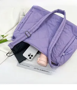 Macro view of purple quilted tote bag showing large capacity and side zipper pocket