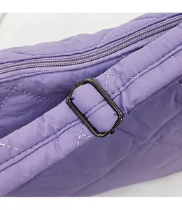 Detail of purple quilted fabric tote bag with adjustable nylon strap and black metal buckle