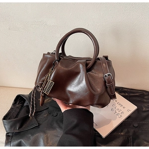 Gros plan détaillé du sac seau plissé marron foncé avec poignée circulaire
