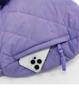 Close-up of the side zipper pocket on a purple quilted tote bag with a smartphone inside