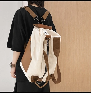 Detail of multi-functional canvas backpack with brown leather trim and side pocket