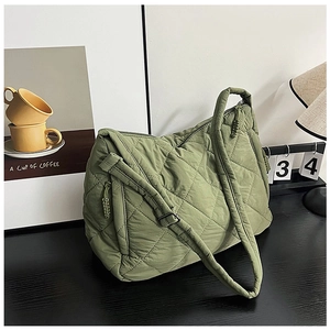 Detail of olive green quilted tote bag with diamond pattern and woven zipper pull