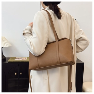 Nahaufnahme der braunen Shopper-Tasche aus Leder mit Lychee-Narbung an einem Model