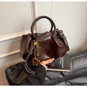 Détail du sac seau plissé marron foncé avec breloque boulier dorée et poignée en cuir