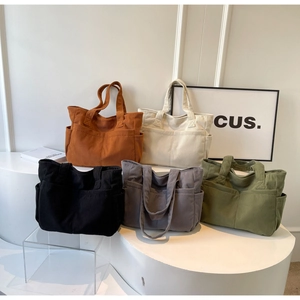Détail de cinq sacs fourre-tout en velours côtelé avec poches texturées sur présentoir